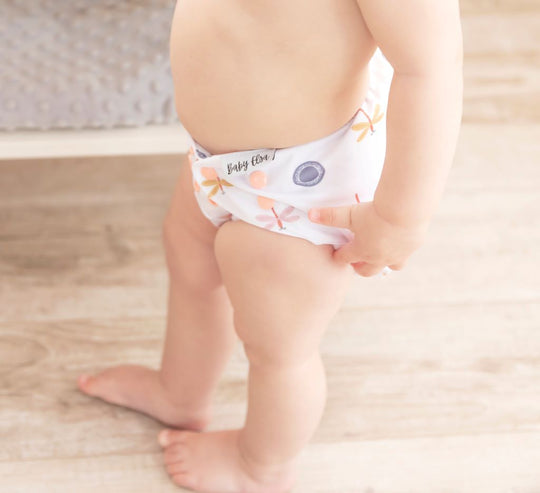 a girl wearing a cloth diaper cover butterfly pattern
